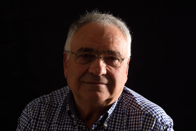 Portrait of a senior man with black background