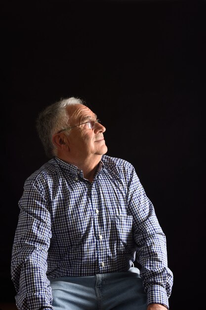 Portrait of a senior man with black background