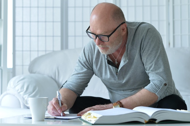 Portrait of senior man with book writing