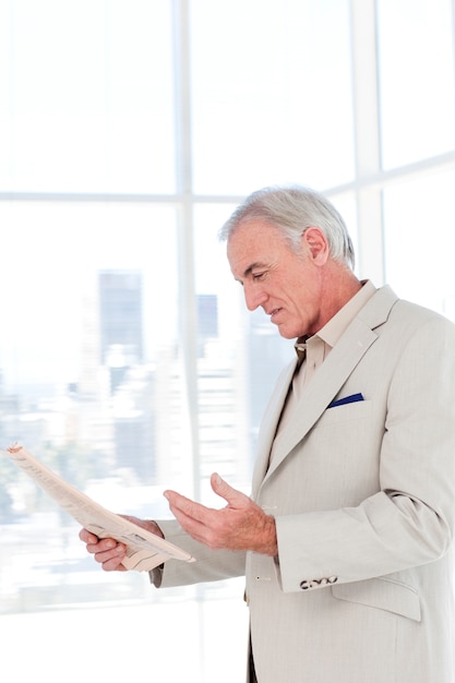 Portrait of a senior manager reading newspaper