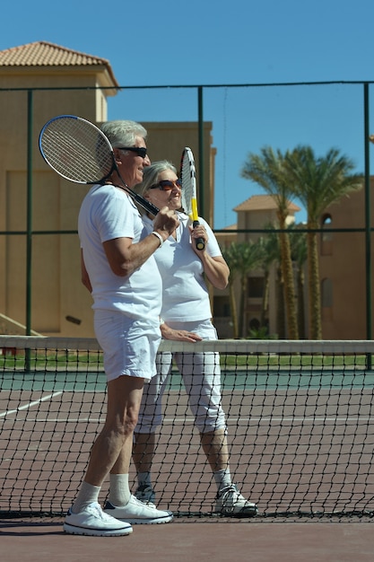 야외에서 테니스를 치는 멋진 노부부의 초상화