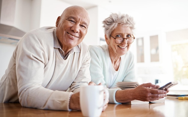 Photo portrait senior and old interracial couple relax in home kitchen in the morning with coffee happy smile and confident together old man and elderly woman on counter enjoying retirement in happiness