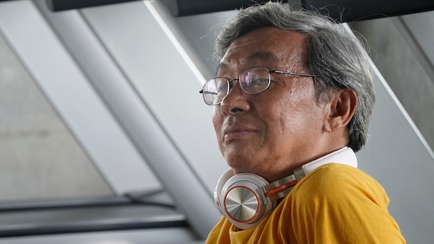 Portrait of senior with eyeglasses doing exercise in  fitness gym.