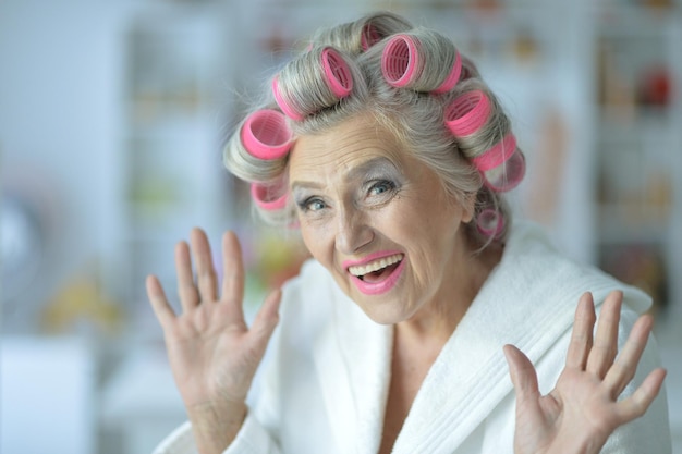 Portrait of senior woman in bathrobe with curlers