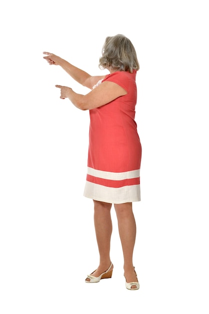 Portrait of senior woman in bright dress on white background