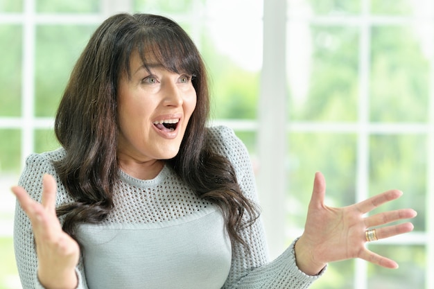 Portrait of a senior woman gestures at home