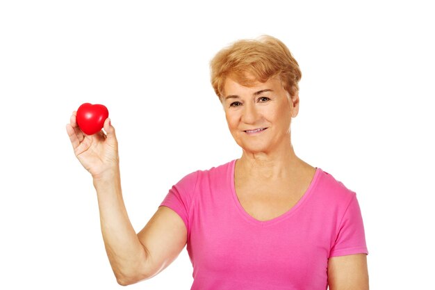 Photo portrait of senior woman holding red heart shape against white background