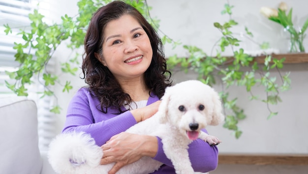 Portrait of senior woman hugging her dog