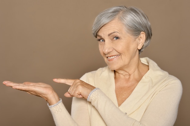 Portrait of senior woman pointing by her finger