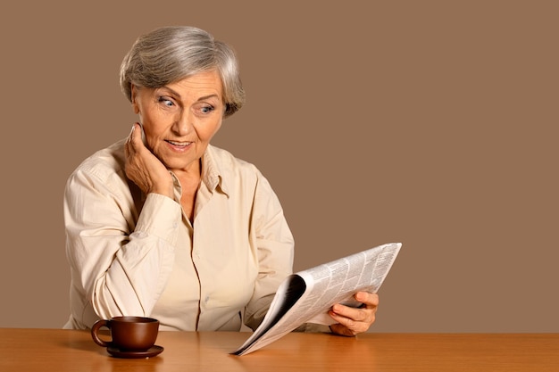 Portrait of senior woman reading newspaper