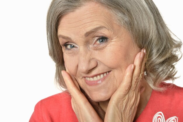 Portrait of senior woman in red dress on white background