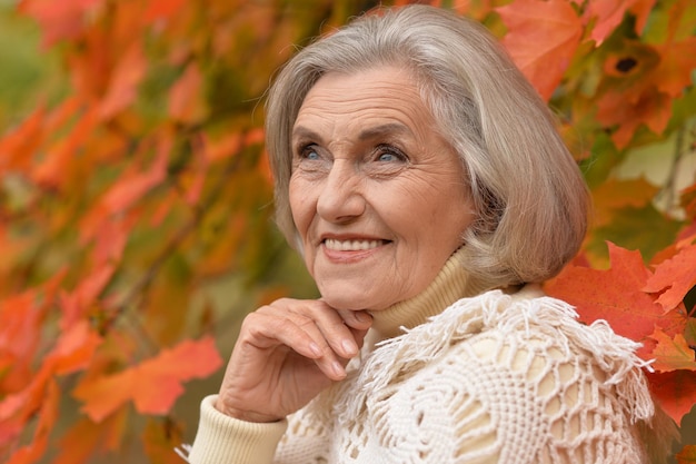 Portrait of senior woman smiling in autumn park