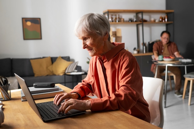 Photo portrait of senior woman using laptop device at home