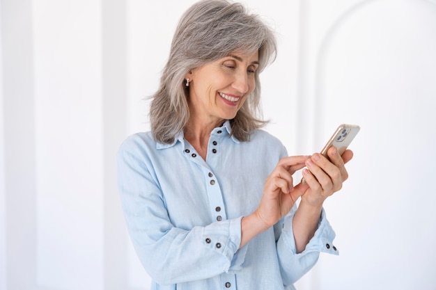 Photo portrait of senior woman using smartphone device