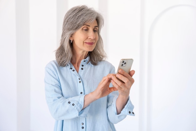 Photo portrait of senior woman using smartphone device