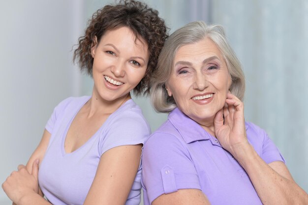 Portrait of senior woman with adult daughter at home