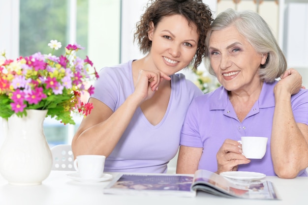 Portrait of Senior woman with daughter with magazine at home