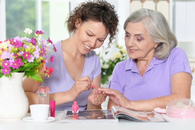 Portrait of Senior woman with daughter with nail polish at home