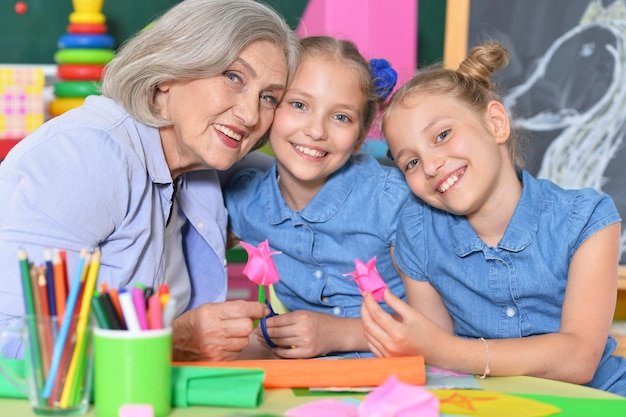 Portrait of senior woman with girls drawing