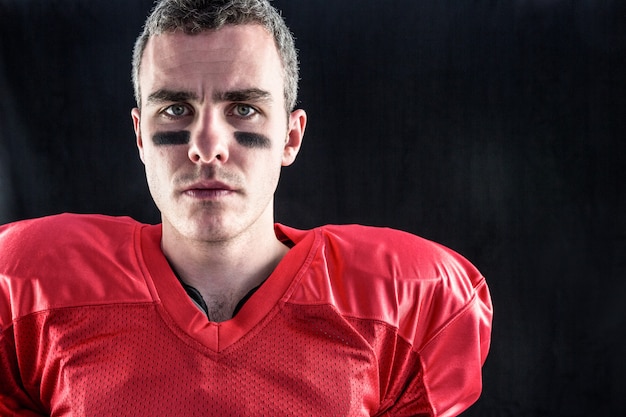 Photo portrait of a serious american football player looking at camera