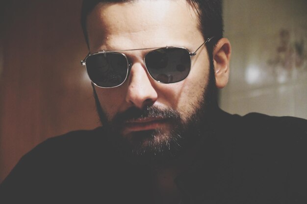 Photo portrait of serious bearded man wearing sunglasses