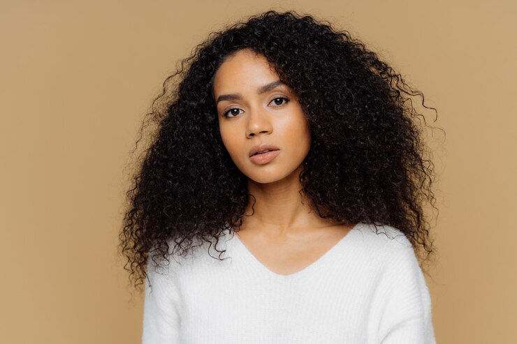 Photo portrait of serious beautiful dark skinned female with frizzy black hair