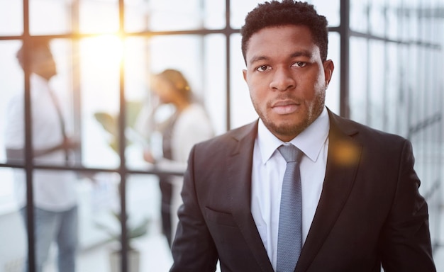 Portrait of a serious businessman in a black suit in the office