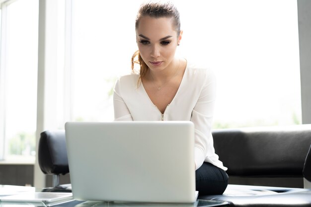 Portrait of a serious businesswoman using laptop in office.