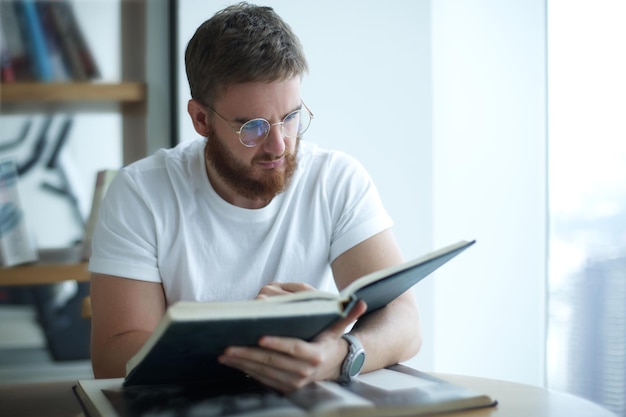 Portrait of serious concentrated guy young man in glasses college or university student is study