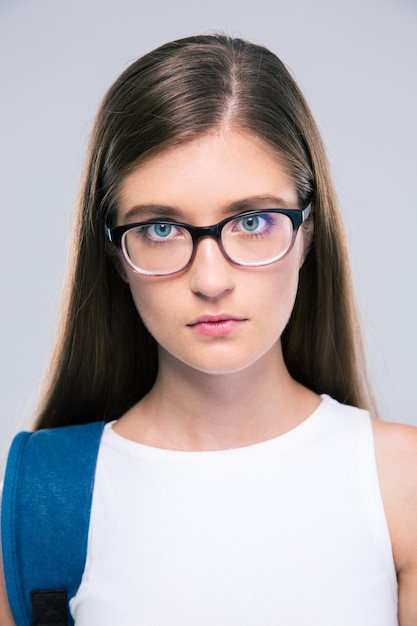 Portrait of a serious female teenager looking at camera isolated