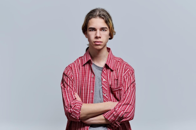 Portrait of serious guy teenager with crossed arms