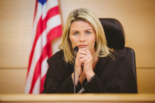 Photo portrait of a serious judge with american flag behind her