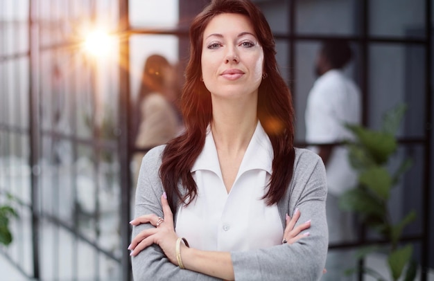 portrait of a serious lady posing against the backdrop of a modern office