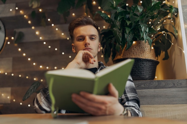 portrait of serious male freelancer with notepad sitting in cafe