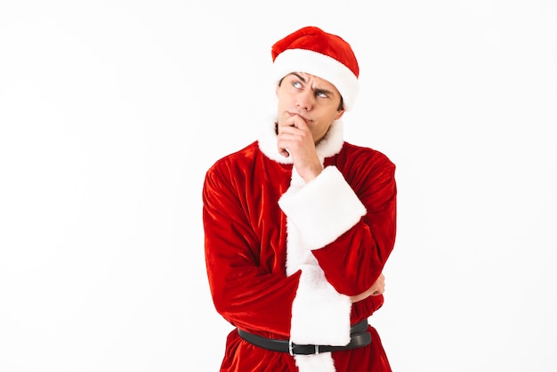 Portrait of serious man 30s in santa claus costume and red hat looking upward