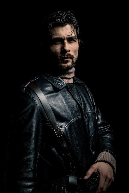 Photo portrait of serious man standing against black background