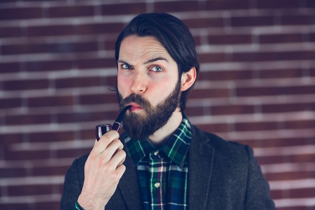 Portrait of serious man with smoking pipe 