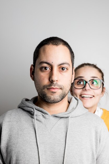 Portrait of serious man with woman against gray background