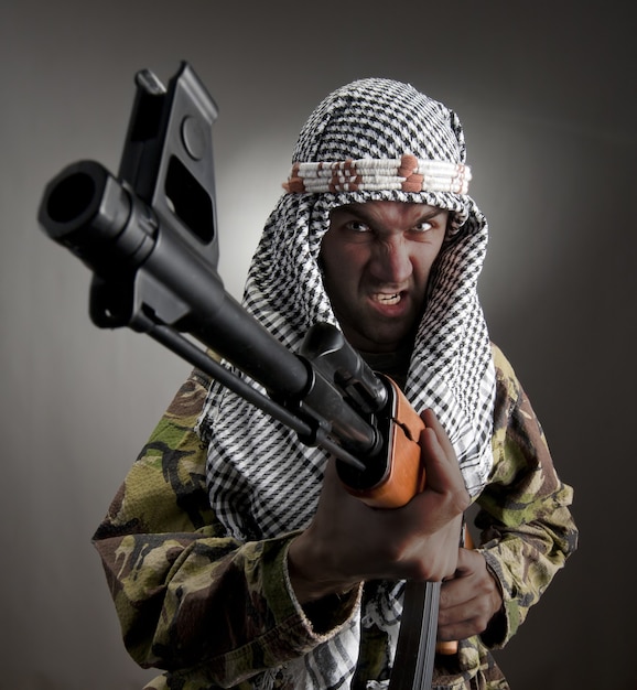 Portrait of serious middle eastern man with AK-47