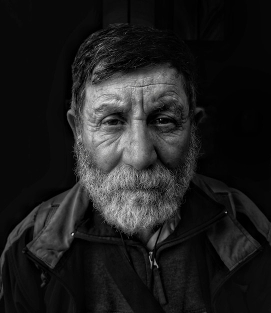Foto ritratto di un uomo anziano serio con il pane sullo sfondo nero