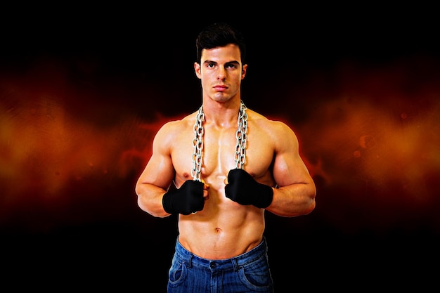 Photo portrait of a serious shirtless young muscular man against dark background