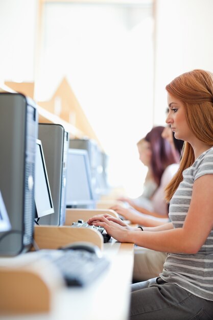 Foto ritratto di uno studente serio che lavora con un computer