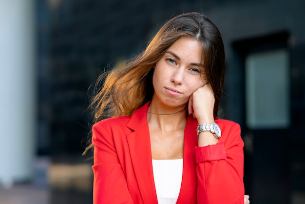 Portrait serious young beautiful pensive woman business woman props her face with her hand boring jo...