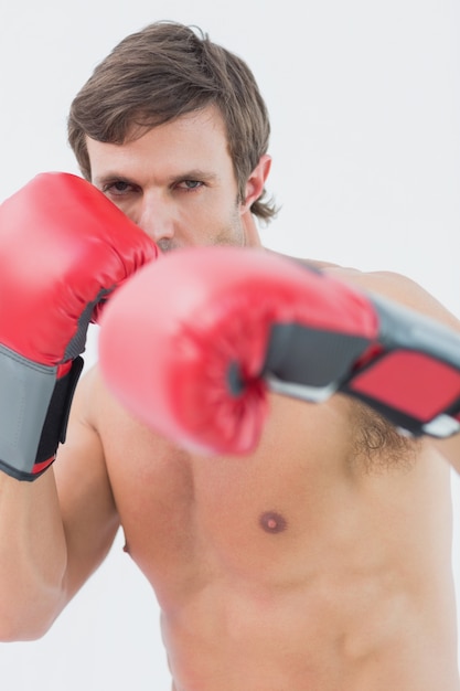 Portrait of a serious young man in red boxing gloves