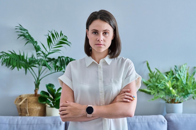 Photo portrait of serious young woman looking at camera with crossed arms