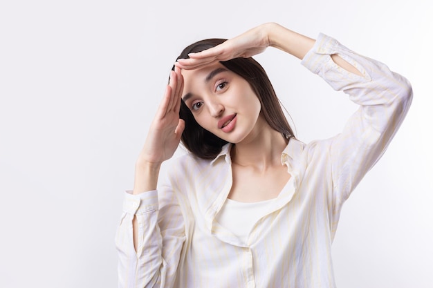 Portrait of a serious young woman showing stop gesture with her palm over white background