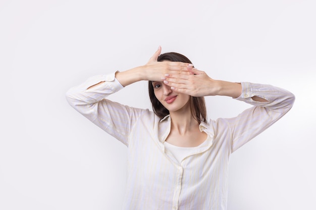 Portrait of a serious young woman showing stop gesture with her palm over white background