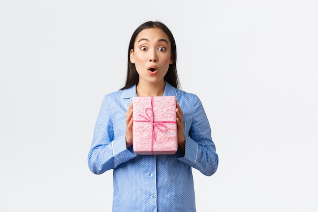 白い背景に立っている真剣な若い女性の肖像画