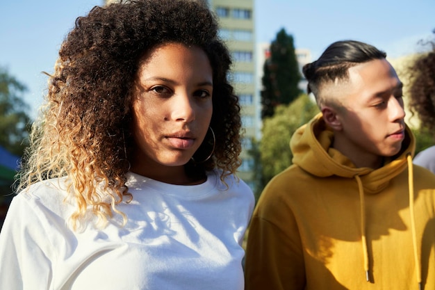 Portrait of serious young woman standing with friend