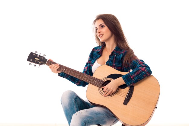 白い背景で隔離の笑顔の手にギターとセクシーな女の子の肖像画